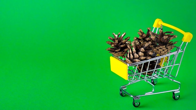 Christmas bumps in a small trolley on green background Bumps in a trolley Copy space