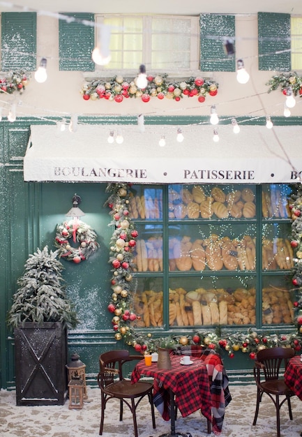 Christmas cafe bakery exterior with Christmas decorations and fresh bread in glass showcase