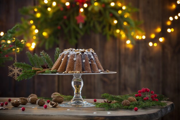 Фото Рождественский торт и еловые ветки на темной деревянной стене