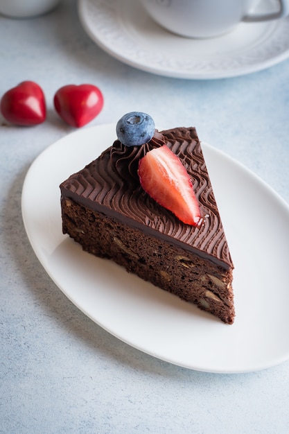 Christmas Cake for Dessert. Delicious Piece of chocolate cake with cup of coffee and milk on blue stone concrete table . Breakfast food concept. Festive Holiday Decoration