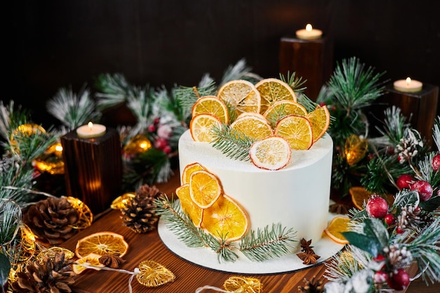 Christmas cake made of chocolate base with cream decorated with dried orange slices