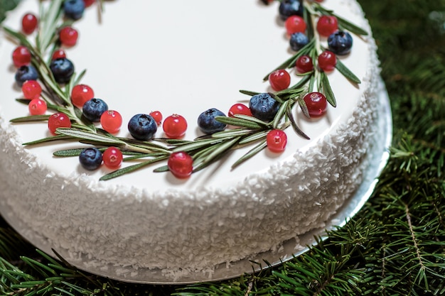 Photo christmas cake with berries on the background of fir branches