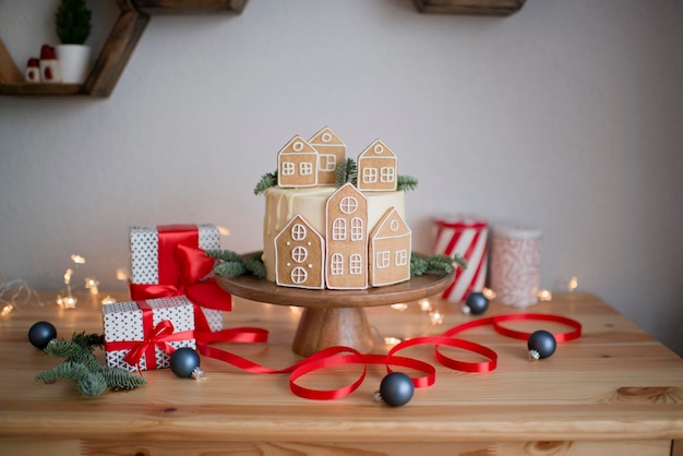 Christmas cake with gingerbread houses on a wooden stand