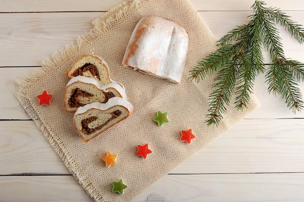 Christmas cake with powdered sugar, cut into slices on the canvas