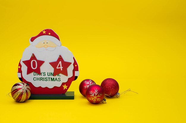 Christmas calendar counting down the days of a wooden Santa Claus.Four days until christmas text.