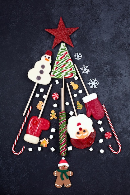 Christmas candies and mini marshmallows on gray background