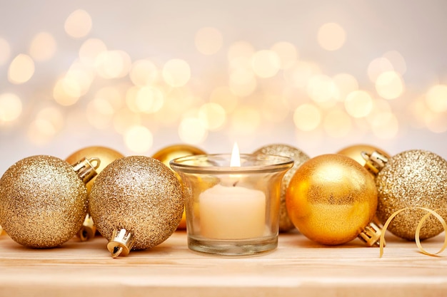 Christmas candle and gold ornaments on defocus lights background