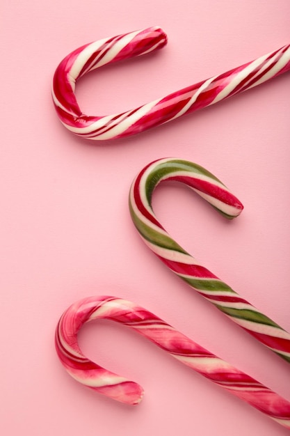 Photo christmas candy cane on pink background vertical photo