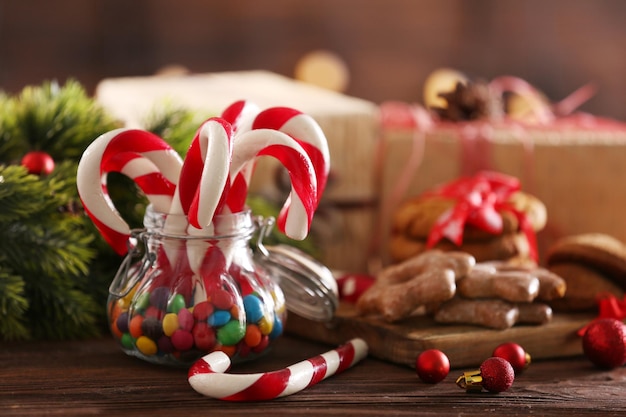 Christmas Candy Canes in jar with Christmas decoration on table on bright background