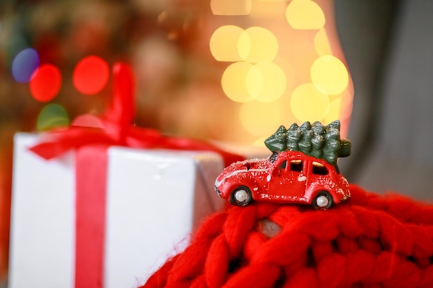 Фото Рождественский автомобиль на фоне белой коробки и расфокусированные желтые огни