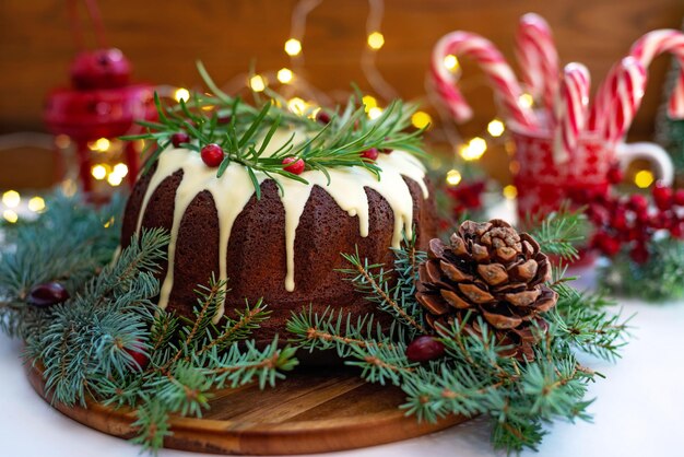 Christmas caramel cake, decorated with white chocolate, cranberry, rosemary and New Year decorations. Festive baked goods. Soft selective focus. Horizontal