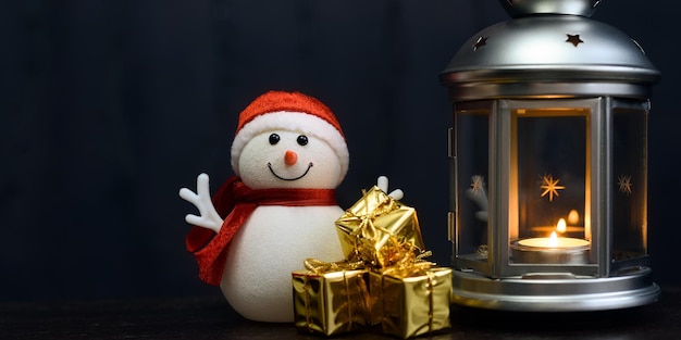 写真 クリスマスカード雪だるまキャンドルとランタンギフトとぼやけたライトと明るい光沢のあるボックス