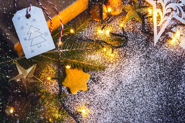 Фото Предпосылка рождественской открытки с рождественской елью, подарком и пряниками.