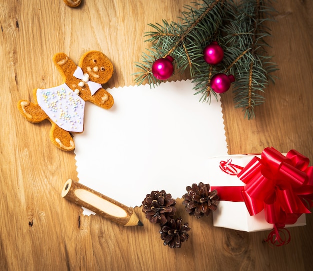 Christmas card: blank, vintage rural gift and christmas tree branch on wooden background with gift