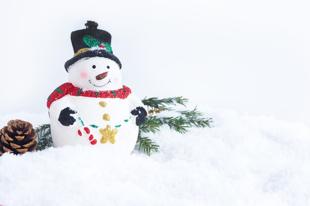 Christmas card. Christmas toy cute snowman, fir branches pine cone in the snow. copy space.