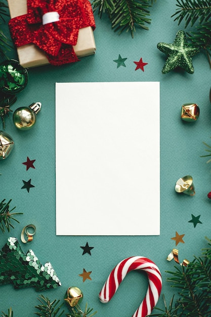 写真 クリスマス カード フラット レイアウト モダンなグリーティング カード スタイリッシュなクリスマスの装飾と緑の背景の装飾品でモックアップ テキスト メリー クリスマスの空のはがきテンプレート スペース