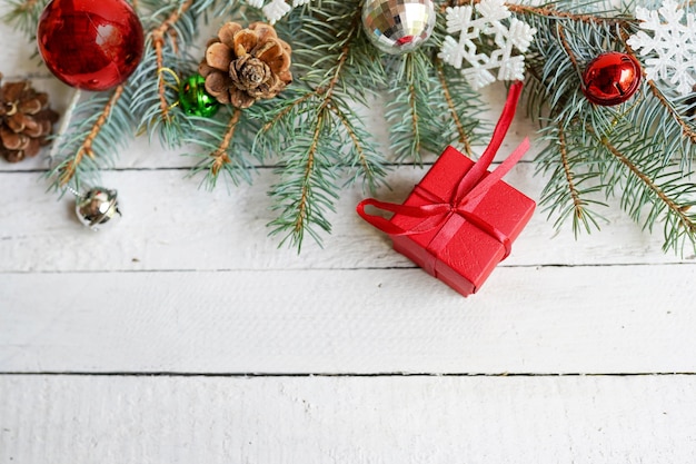 Christmas card, gift, pine cones, toys on wooden white. copy space