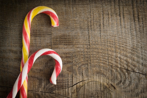 Foto cartolina di natale con caramelle su fondo in legno