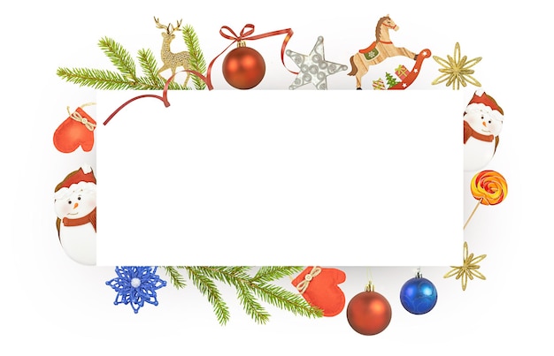 Photo christmas card with a copy space and decor of fir branches, candy and christmas toys on a white back