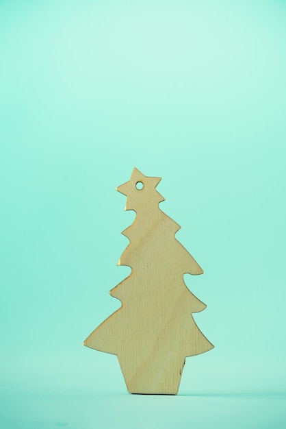 Christmas card with decorative wooden Christmas tree on blue background. 