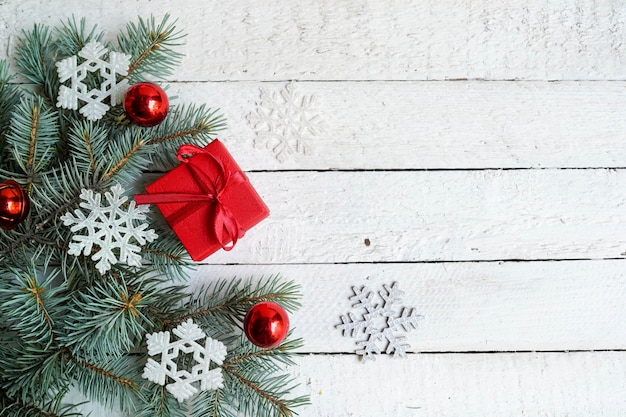 Рождественская открытка с подарочной коробкой и елочными украшениями на белом фоне