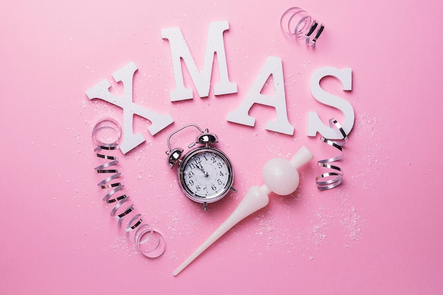 Christmas card with letters and clock on the pink background. Christmas concept, top down view