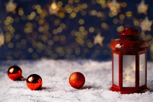 金色のボケ味の背景に星と赤い提灯が付いたクリスマスカード