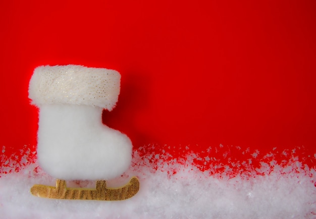 Foto cartolina di natale con un pattino bianco nella neve.