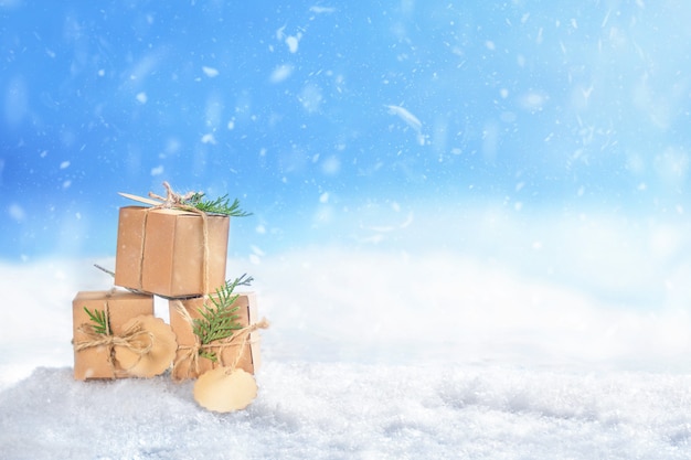 Christmas cardboard gifts boxes in snow on winter landscape