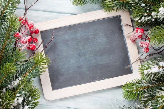 Photo christmas chalkboard and fir tree with snow