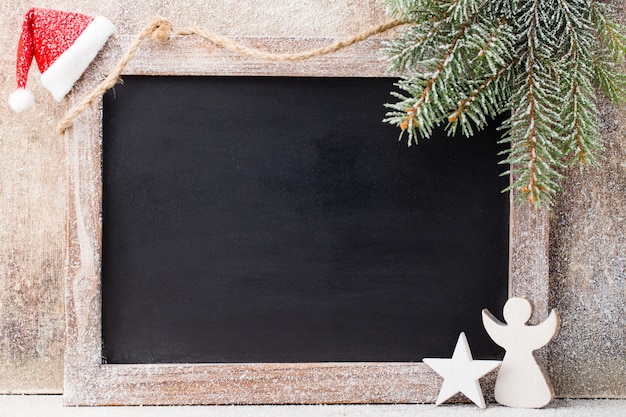 Christmas chalkboard with decoration. Santa hat, stars,  wooden table. Vintage Rustic Style.