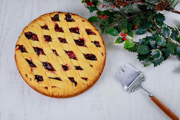 Christmas cherry pie cake with wooden background. 