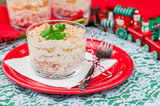 Photo christmas chicken, apple, cheese and egg salad layered with mayonnaise