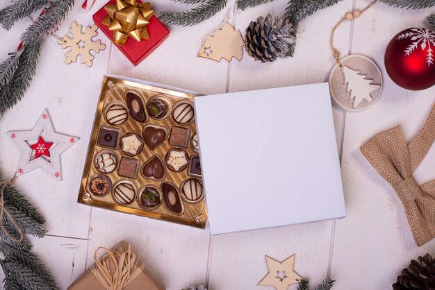 Christmas chocolate candy box on a wooden table with seasonal holiday decoration