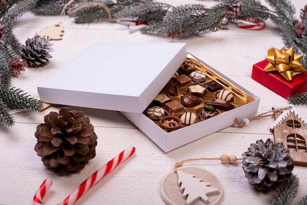 Christmas chocolate candy box on a wooden table with seasonal holiday decoration