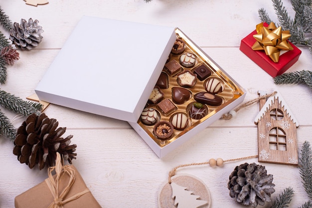 Christmas chocolate candy box on a wooden table with seasonal holiday decoration