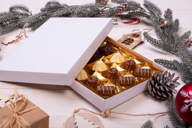 Christmas chocolate candy box on a wooden table with seasonal holiday decoration