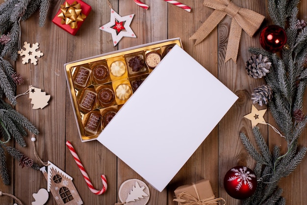 Christmas chocolate candy box on a wooden table with seasonal holiday decoration