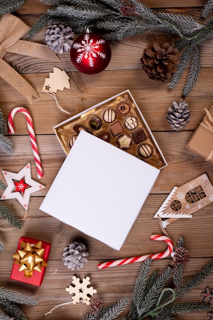 Christmas chocolate candy box on a wooden table with seasonal holiday decoration