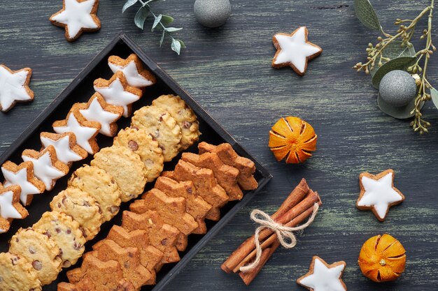 Christmas chocolate chip cookies, flat lay with spices and winter decorations on dark