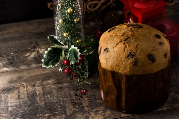 Foto torta del panettone del cioccolato di natale con natale decorato sulla tabella di legno. copyspace