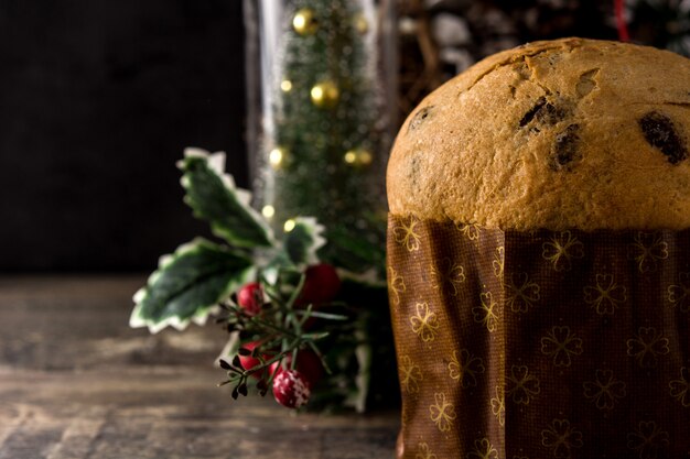 Foto torta del panettone del cioccolato di natale con natale decorato sulla tabella di legno. copyspace