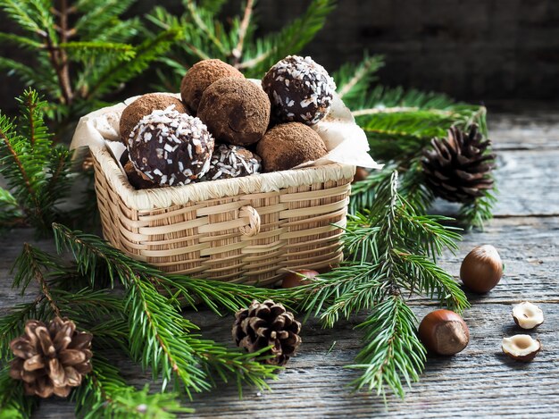 Tartufi di cioccolato di natale in una scatola di vimini i rami di abete sulla tavola di legno