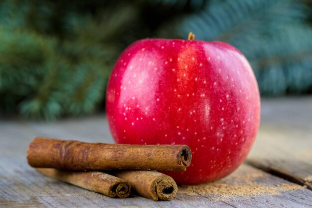 Christmas cinnamon sticks with apple on wooden table