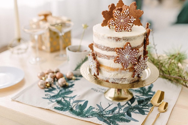 Foto decorazioni natalizie classiche per la cucina. torta nuda bianca di natale con stelle di biscotti di pan di zenzero