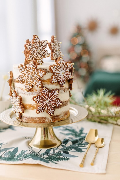 Christmas classic kitchen decorations. Christmas white naked cake with gingerbread cookies stars
