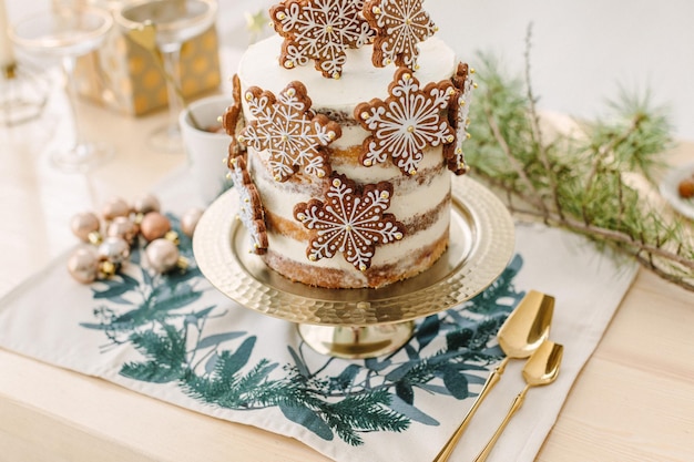 Christmas classic kitchen decorations. Christmas white naked cake with gingerbread cookies stars