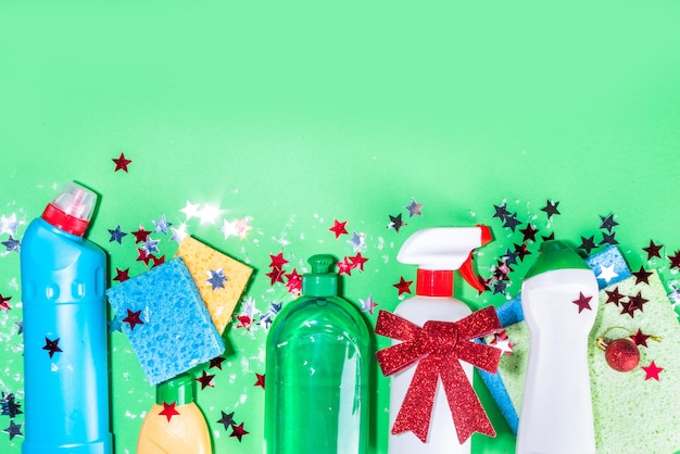 Christmas cleaning concept. Various bottles, equipment, and accessories, gloves for cleaning with christmas decor and santa hat. Cleaning service advertising mockup background