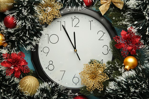 Christmas clock with winter decoration on snow. Happy new year concept.