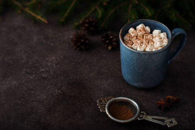 Christmas cocoa with marshmallows in a mug, Christmas tree, copy of space